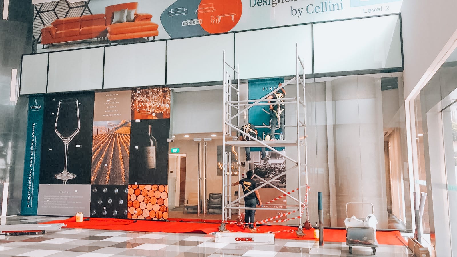 Shopfront glass stickers being installed on a scaffold — glass stickers for windows in Singapore by Garrison Productions