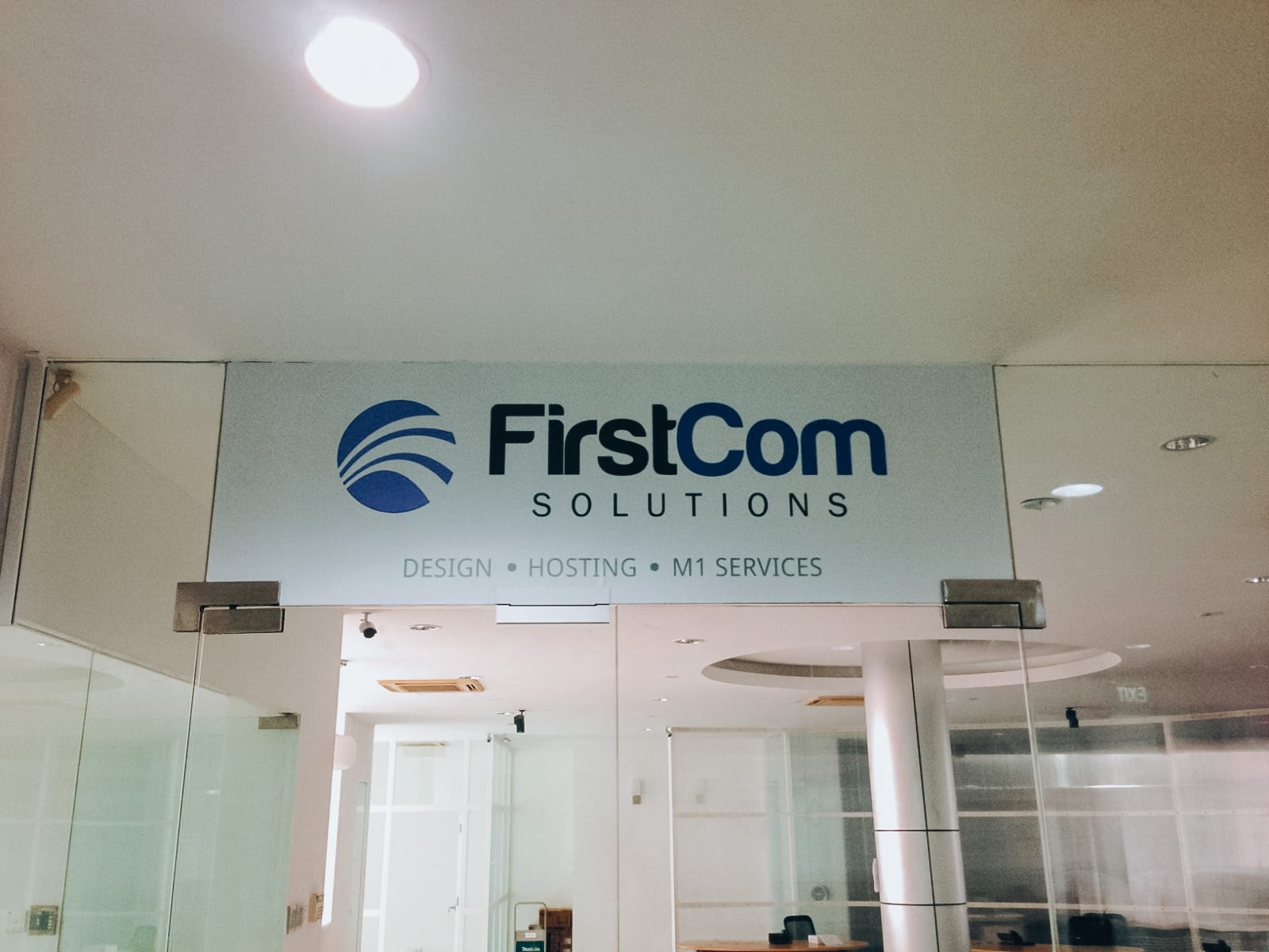 FirstCom Solutions logo glass sticker — glass sticker in Singapore by Garrison Productions