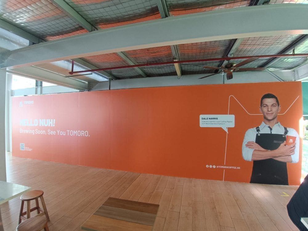 Orange café hoarding with barista photo — Hoarding Sticker Printing by Garrison Productions, Singapore