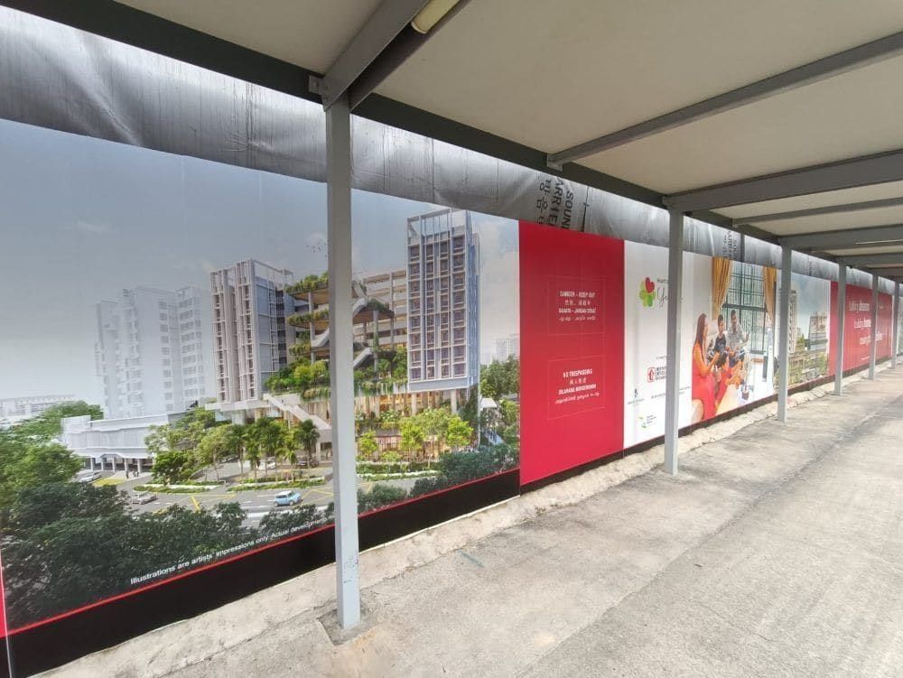 HDB development hoarding along a covered walkway — Hoarding Sticker Printing by Garrison Productions, Singapore