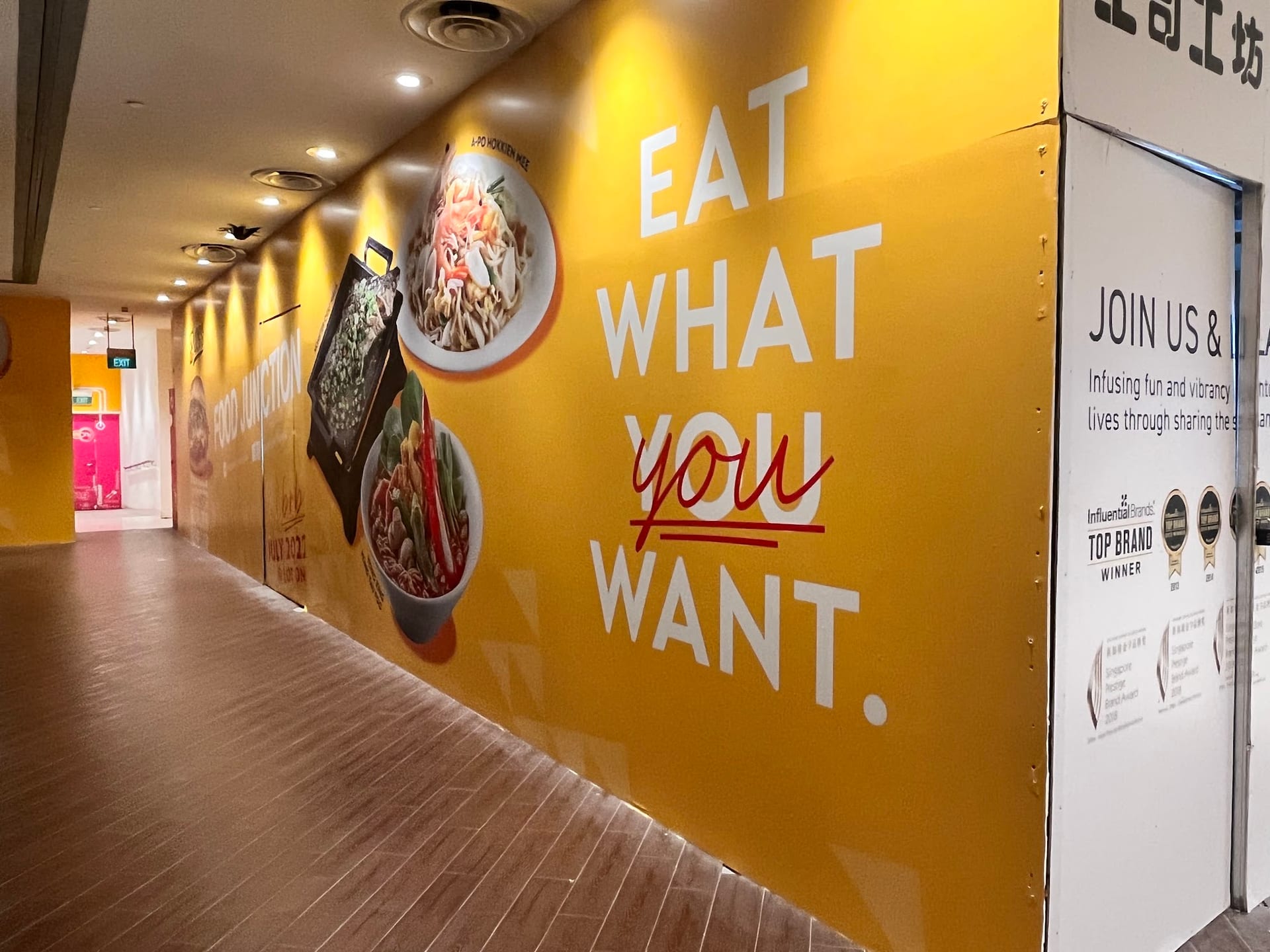 "Eat what you want" yellow food court hoarding — Hoarding Sticker Printing by Garrison Productions, Singapore