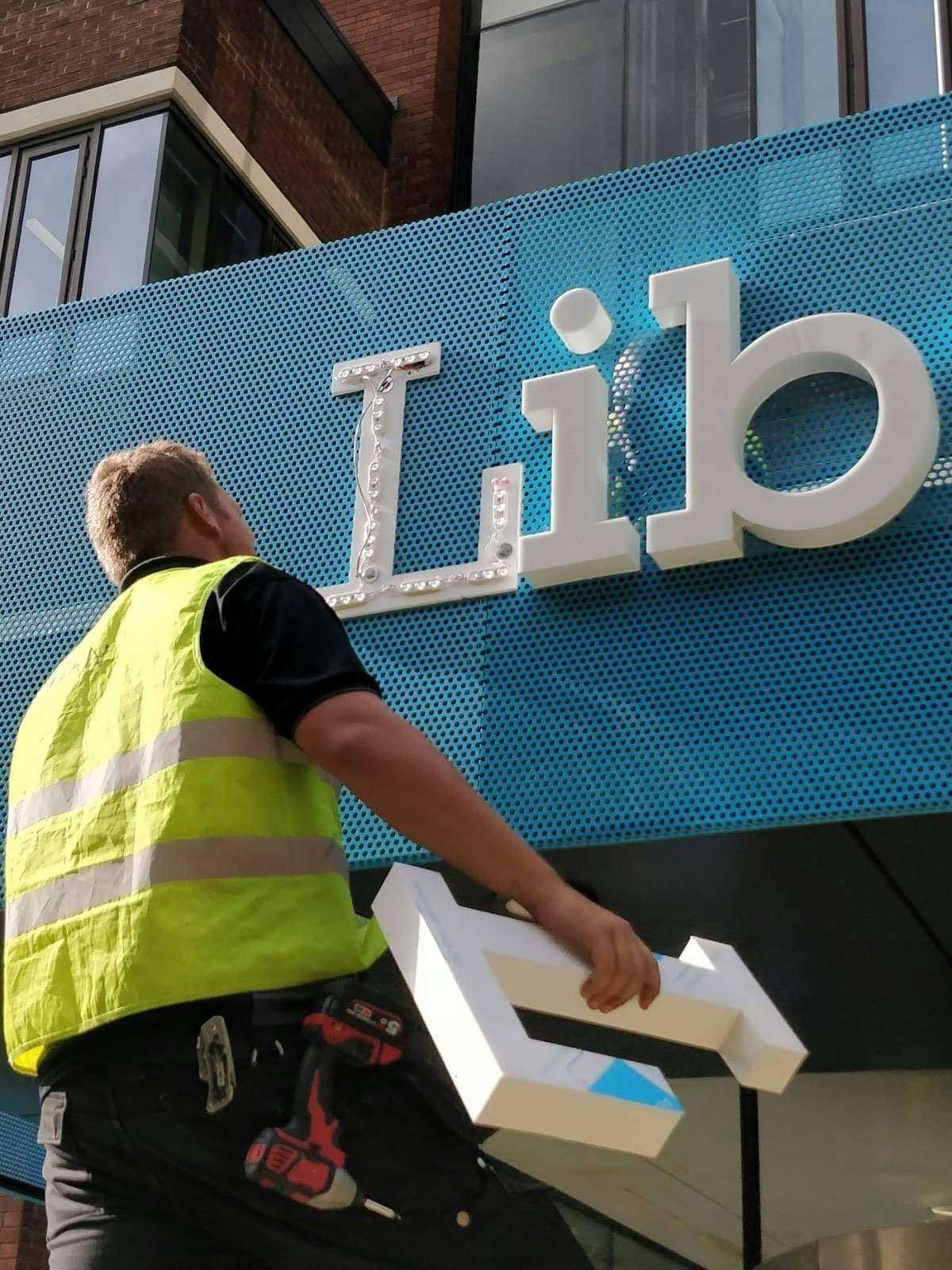 Garrison Productions installing illuminated channel-letter signage